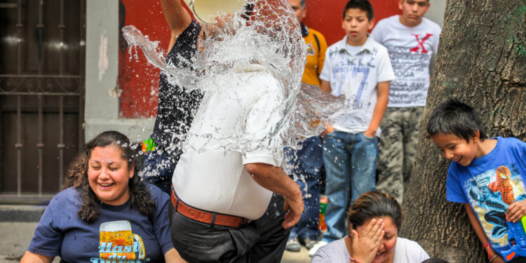 Mexico City, Mexico, Apr 03 - Celebrations of Holy Saturday or Glory Saturday (Sabado de Gloria) in the center of Mexico City, with the cheerful and traditional water battle between young people and friends.