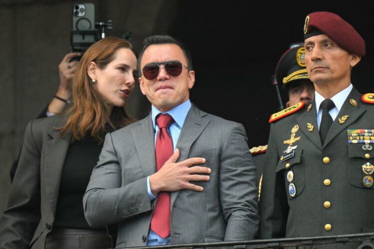 Ecuador's President reelect Daniel Noboa (C) acknowledges supporters accompanied by his wife, Lavinia Valbonesi (L) and the chief of the Presidential Military House, Milton Rodriguez, from a balcony of the Carondelet Presidential Palace during the changing of the guard ceremony in Quito on April 15, 2025. Ecuador's President reelect Daniel Noboa faces the herculean task of uniting his violence-struck nation, after his leftist rival Luisa Gonzalez called his victory into question. (Photo by Rodrigo BUENDIA / AFP)