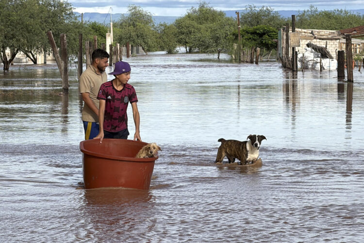 Personas cruzan en medio de una inundación causada por el paso de la tormenta tropical Polo este martes, en Guaymas al sur de Sonora (México). Polo se debilitó a tormenta tropical en su paso por el estado de Sonora (noroeste de México), donde recién tocó tierra por segunda vez y se espera que siga perdiendo intensidad para disiparse el miércoles. EFE/ Daniel Sánchez