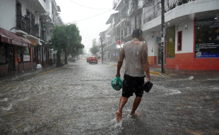 FOTODELDÍA MEX5528. PUERTO VALLARTA (MÉXICO), 13/10/2026.- Un hombre camina por una calle inundada por lluvias provocadas por el huracán Simón este martes, mientras la tormenta tropical Trudy se formó en el Pacífico mexicano a partir de la depresión tropical Veintiuno-E, en Puerto Vallarta (México). EFE/ Arturo Montero